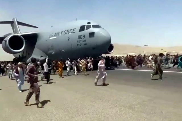 Picture of US Air Force plane in Afghanistan with people running below